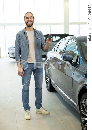 Confident young man in casual clothes near the car Confident young man in casual clothes near the car 116406440