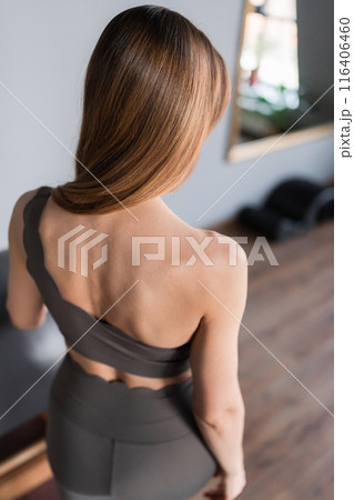 Pilates fitness trainer in pilates studio. Young sporty attractive woman wearing sportswear in yoga studio. Fit, healthy and strong authentical body. Fitness concept 116406460