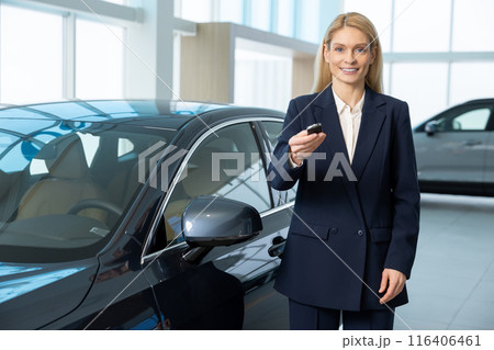 Elegant blonde woman holding a car key in hands 116406461