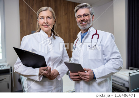 Doctors in lab coats standing close and looking confident 116406471