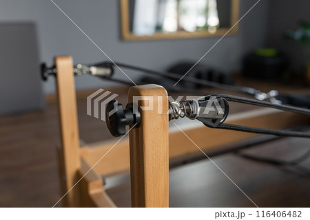 Pilates equipment. Reformer bed. Reformer pilates studio machine for fitness workouts in gym. Fit, healthy and strong authentical body. Fitness concept 116406482