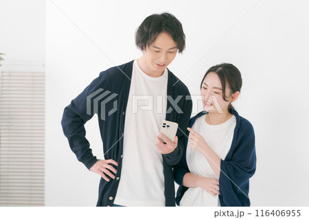 スマホを見る笑顔の男女 116406955
