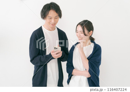 スマホを見る笑顔の男女 スマホを見る笑顔の男女 116407224