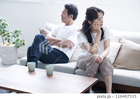 ソファーに座る倦怠期やケンカをする50代夫婦 仲が悪い冷え切った夫婦のイメージ 全身 ソファーに座る倦怠期やケンカをする50代夫婦 仲が悪い冷え切った夫婦のイメージ 全身 116407515