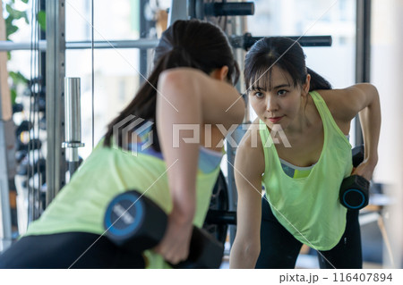 スポーツジムでトレーニングする若い女性 スポーツジムでトレーニングする若い女性 116407894