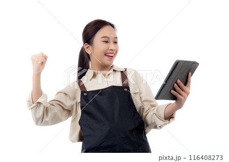 Portrait young asian barista woman wearing an apron celebrating success while using a tablet. Portrait young asian barista woman wearing an apron celebrating success while using a tablet. 116408273