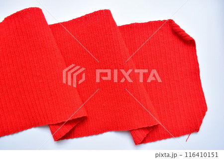wavy of red wool knitted yarn texture, woolen fabric on white background wavy of red wool knitted yarn texture, woolen fabric on white background 116410151