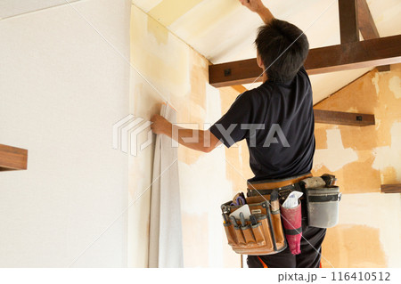 中古住宅の壁紙クロスを貼る職人 116410512