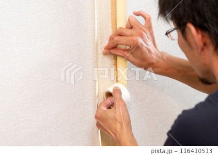 中古住宅の壁紙クロスを貼る職人 116410513