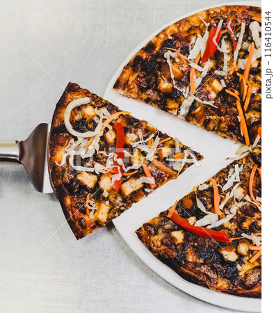 woman taking a slice of the pizza on table. 116410544