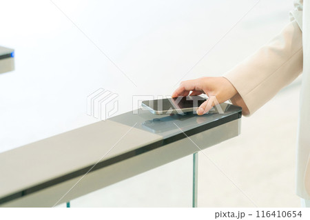 セキュリティゲートを通過する人の手元 116410654