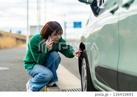 車のトラブルで電話する女性 自動車事故で困る女性 車のトラブルで電話する女性 自動車事故で困る女性 116410691