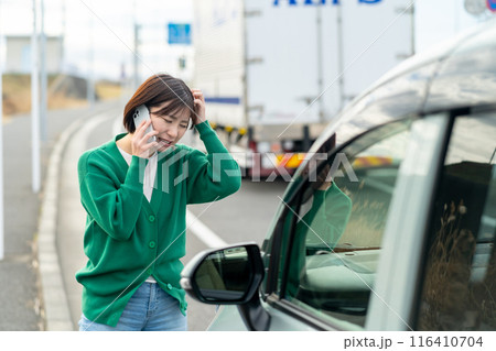 車のトラブルで電話する女性　自動車事故で困る女性 116410704