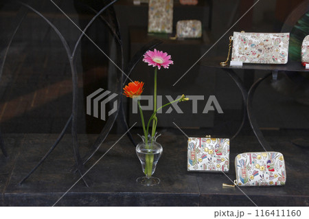 綺麗な花が活けられたオシャレなウインドウ。商品の財布もセンスの良い色合いです 116411160