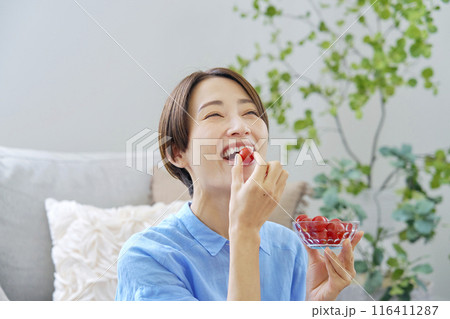 自宅でミニトマトを食べる女性 自宅でミニトマトを食べる女性 116411287