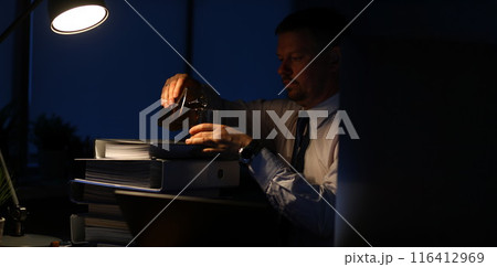 Exhausted male drinking alcoholic drinks 116412969