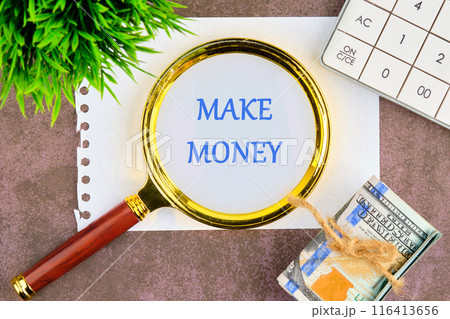 Business and Make Money concept. Copy space. Make Money symbol through a magnifying glass in a composition with American dollars, a calculator and a plant 116413656