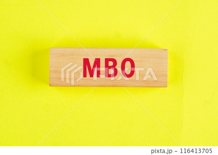 The letters MBO It is an abbreviation for Management by Objectives. MBO on wooden blocks on a bright lemon background. View from above 116413705