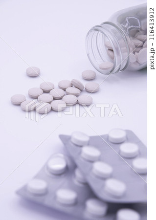 薬瓶に入った薄ピンクの薬とPTP包装の白色の薬 116413912