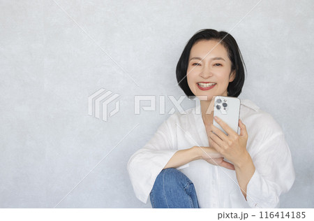スマホを持ち笑顔の女性 スマホを持ち笑顔の女性 116414185