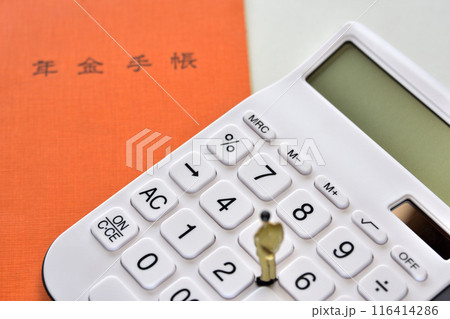 将来悩むサラリーマン年金手帳と電卓 116414286