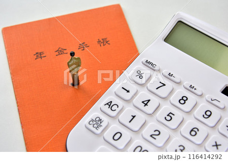 将来悩むサラリーマン年金手帳と電卓 116414292