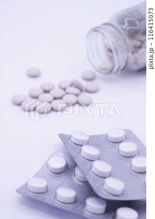 薬瓶に入った薄ピンクの薬とPTP包装の白色の薬 PTPにピント 薬瓶に入った薄ピンクの薬とPTP包装の白色の薬 PTPにピント 116415073