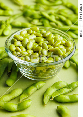 Green edamame pods. Fresh soybeans in bowl on green table. Green edamame pods. Fresh soybeans in bowl on green table. 116415604