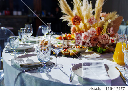 Served round table with empty dishes, snacks and a bouquet of flowers. Served round table with empty dishes, snacks and a bouquet of flowers. 116417477