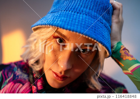 Confident blonde woman wearing trendy clothes sitting at studio and looking at the camera. 116418848