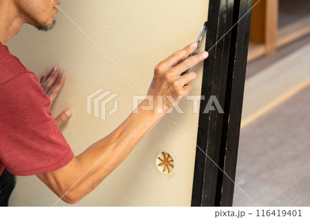 中古住宅の古い襖のクロスを張り替える職人 中古住宅の古い襖のクロスを張り替える職人 116419401