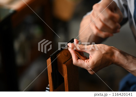 Close up leather craftsman sewing leather with a needle. Small business and handmade concept 116420141