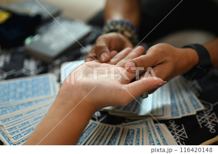 Close up shot fortune teller reading palm lines during fortune telling. Forecasting and divination concept 116420148