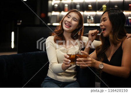 Happy young women dancing and having fun in a night club. Nightlife, celebrations and friendship concept 116420150