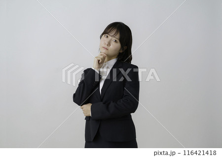 白背景のスーツを着た困った顔をする若い女性のポートレート 白背景のスーツを着た困った顔をする若い女性のポートレート 116421418