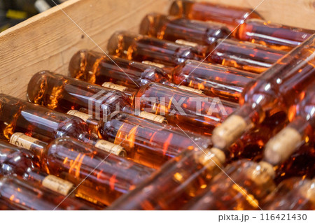 Wooden crate holding stacked bottles of wine for storage in a distillery setting Wooden crate holding stacked bottles of wine for storage in a distillery setting 116421430