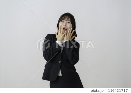 白背景のスーツを驚いた顔の若い女性のポートレート 白背景のスーツを驚いた顔の若い女性のポートレート 116421717