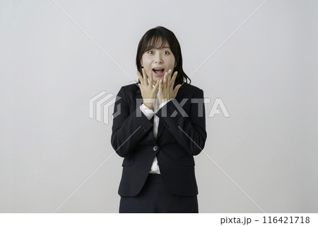 白背景のスーツを驚いた顔の若い女性のポートレート 白背景のスーツを驚いた顔の若い女性のポートレート 116421718