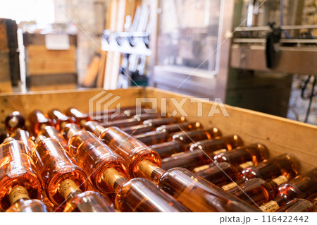 The Wooden Crate holds rows of Rose Wine Bottles arranged at a Distillery The Wooden Crate holds rows of Rose Wine Bottles arranged at a Distillery 116422442