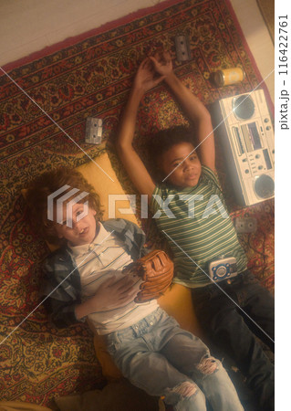 Boys Lying on Carpet with Boombox and Cassettes 116422761