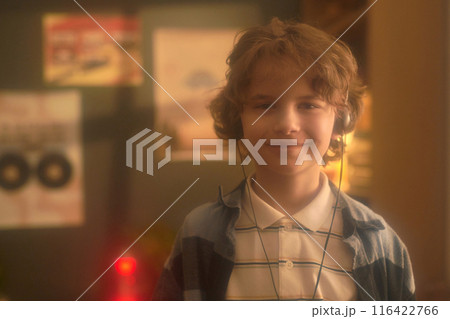 Portrait of Smiling Boy Wearing Headphones Indoors 116422766