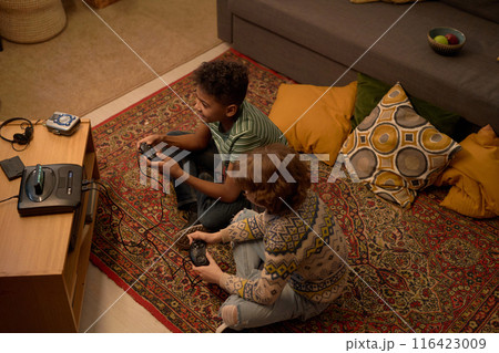 Two Multiethnic Boys Enjoying Retro Video Game Session Two Multiethnic Boys Enjoying Retro Video Game Session 116423009