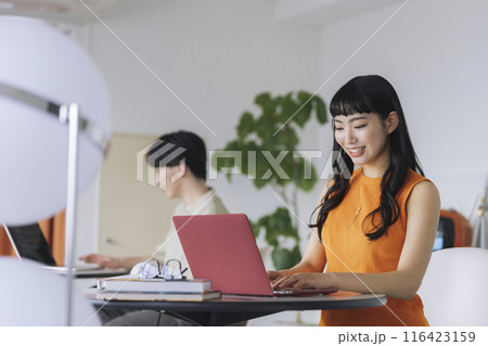 ノートパソコンで作業をする若い女性 ノートパソコンで作業をする若い女性 116423159
