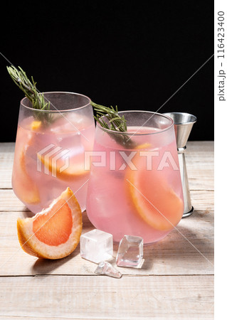 Grapefruit cocktail decorated with rosemary on wooden table 116423400