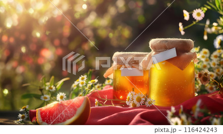 Jars of Honey and Fresh Oranges in a Sunlit Garden 116424243