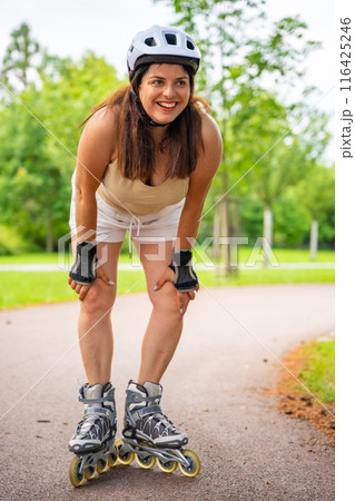 Roller skater woman in park rollerblading on inline skates. Outdoor activities. Summer roller skating. 116425246