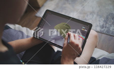 Boy with digital stylus and tablet in hands sits at home Boy with digital stylus and tablet in hands sits at home 116427229