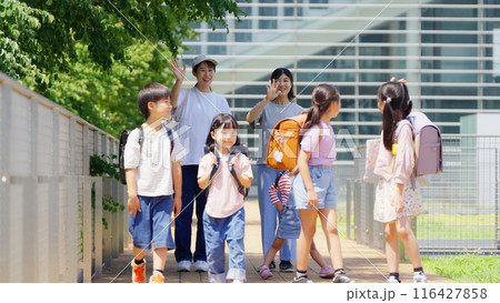 登校班の子供達を見送る母親 116427858