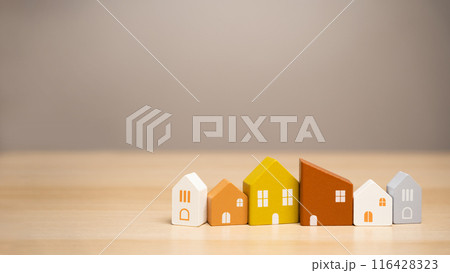 Wooden houses stand in a row. Real estate, affordable housing concept. Valuation of residential buildings. Realtor services. Buying and selling. Find most suitable housing options. Mortgage and loan Wooden houses stand in a row. Real estate, affordable housing concept. Valuation of residential buildings. Realtor services. Buying and selling. Find most suitable housing options. Mortgage and loan 116428323