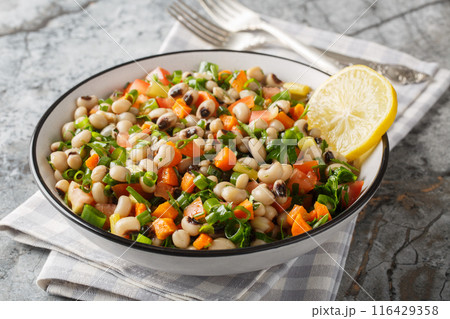 Salad of Mavromatika of Feneos made with black-eyed peas and vegetables closeup on the plate. Horizontal 116429358